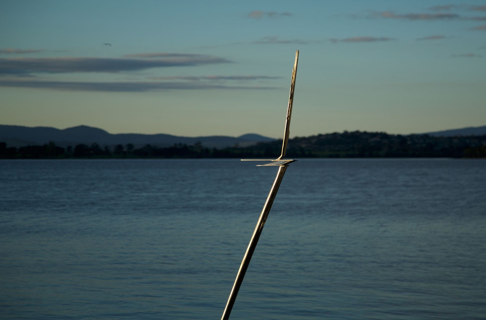 A straight stick partially submerged in water, appearing bent due to refraction